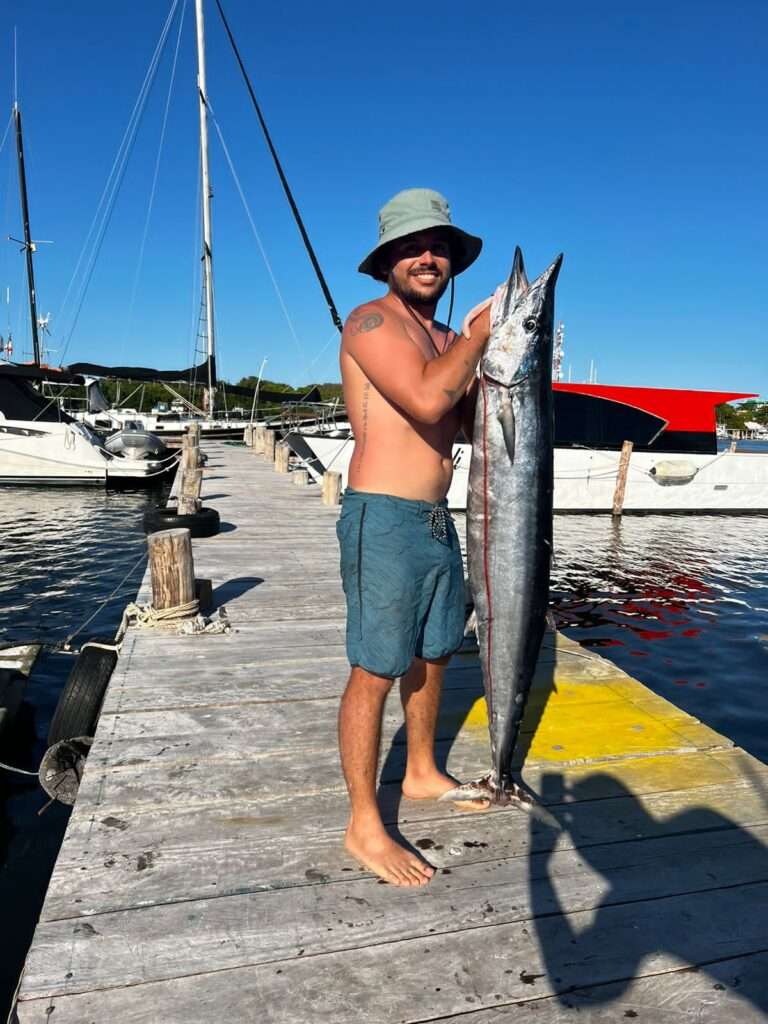 Angler holding a wahoo on the dock in Isla Mujeres