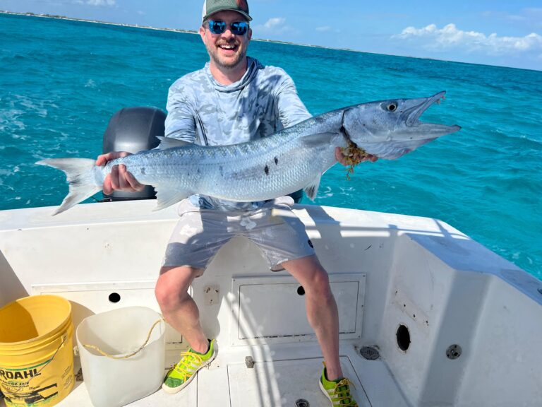 Guest holding a barracuda caught on the fishing charter