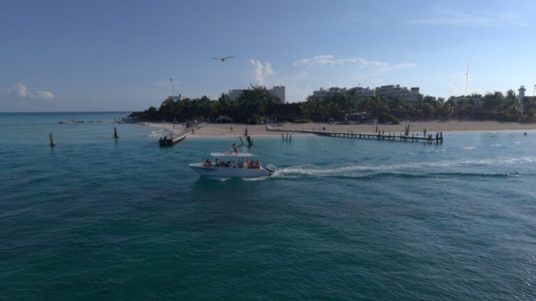 Aerial view of an Isla Sea Tours boat leaving the beach in Isla Mujeres