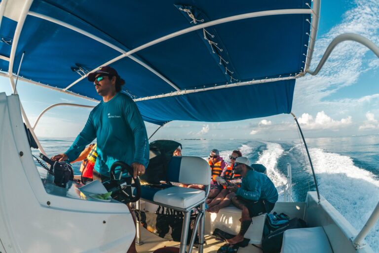 Isla Sea Tours captain at the helm while guests sit in the back, Isla Mujeres