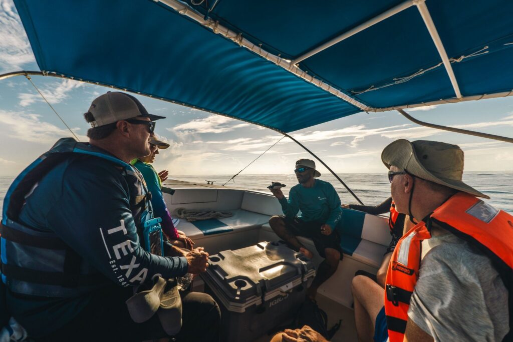Guide explaining about whale sharks to guests on board the boat