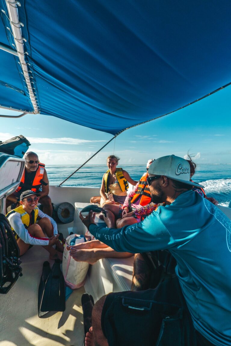 Guide showing a whale shark plush toy to guests on the boat