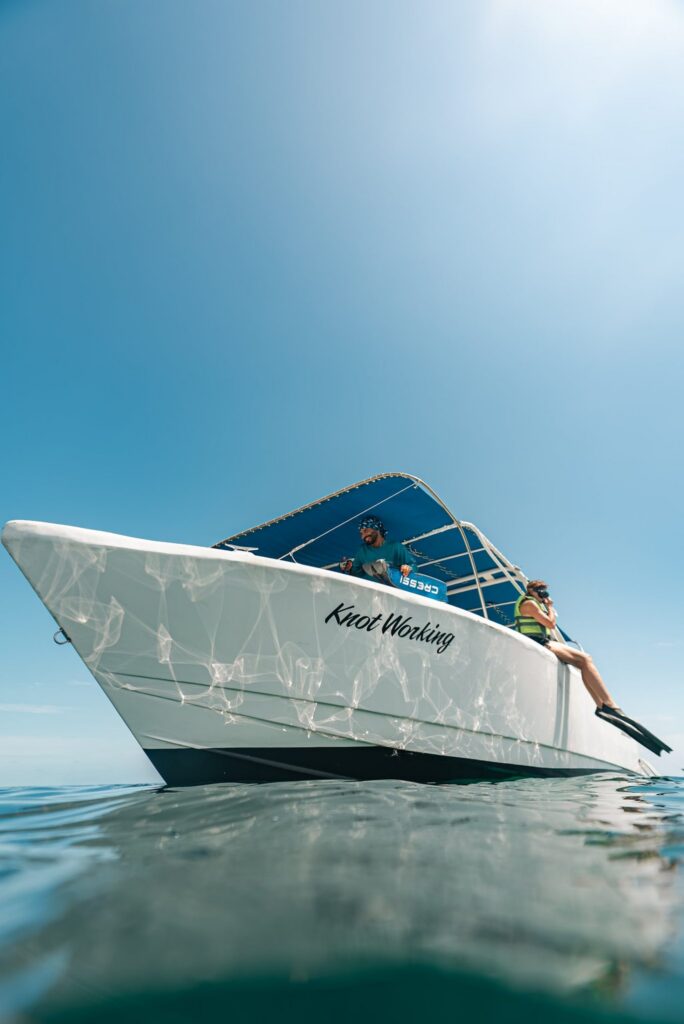 Isla Sea Tours boat "Knot Working" floating on blue water with guide and guest