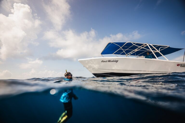 Snorkeler in the water next to the Isla Sea Tours boat "Knot Working"