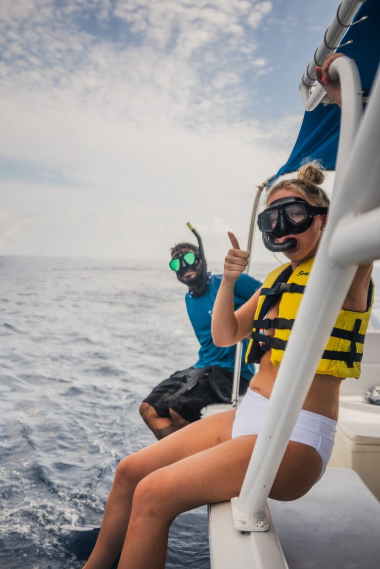 Smiling guest giving a thumbs up in snorkel gear on the Isla Sea Tours boat