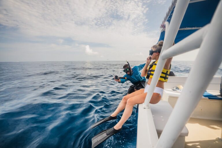 Snorkeler and guide sitting on the boat edge ready to jump into the sea