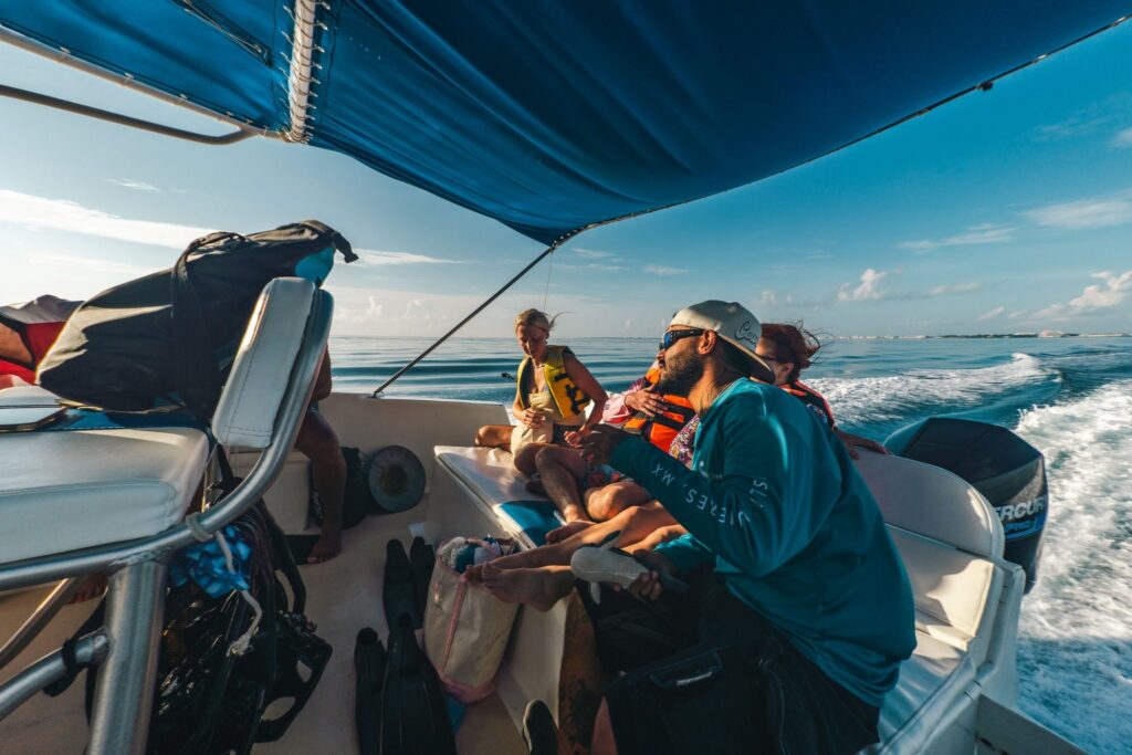 Isla Sea Tours guide talking with guests on the boat under the blue canopy, Isla Mujeres